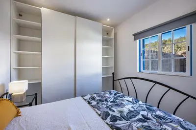 a bedroom with a bed and a window at Salema Beach House in Salema