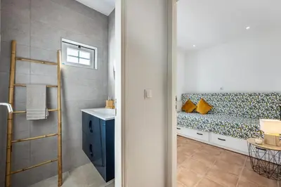 a bathroom with a bench and a sink at Salema Beach House in Salema