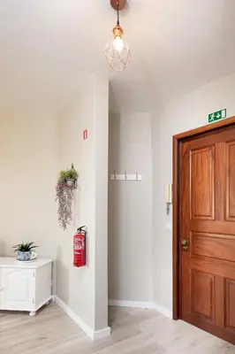 a hallway with a wooden door and a fire hydrant at ALEGRIA II in Funchal