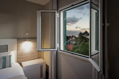 a bedroom with a window with a view of a city at ALEGRIA II in Funchal