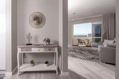 a white living room with a table and a living room at ALEGRIA II in Funchal