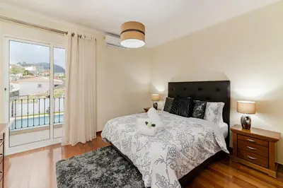 a bedroom with a bed and a balcony at Exquisite Madeira Villa Villa Funchal Belair 4 Bedroom Panoramic Sea View in Funchal