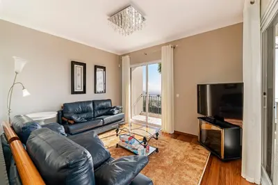 a living room with a leather couch and a television at Exquisite Madeira Villa Villa Funchal Belair 4 Bedroom Panoramic Sea View in Funchal