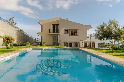 a swimming pool in front of a house at Exquisite Madeira Villa Villa Funchal Belair 4 Bedroom Panoramic Sea View in Funchal