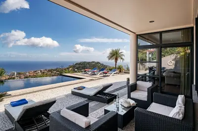 an outdoor patio with a view of the ocean at Exquisite Madeira Villa Villa Funchal Luz 5 Bedroom Heated Pool in Funchal