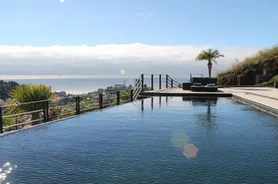 a swimming pool with a view of the ocean at Exquisite Madeira Villa Villa Funchal Luz 5 Bedroom Heated Pool in Funchal