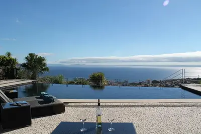 a swimming pool with a view of the water at Exquisite Madeira Villa Villa Funchal Luz 5 Bedroom Heated Pool in Funchal