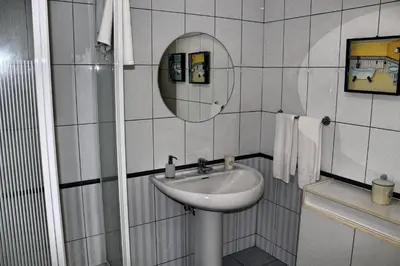 a white bathroom with a sink and a mirror at Exquisite Madeira Villa Villa Funchal Luz 5 Bedroom Heated Pool in Funchal