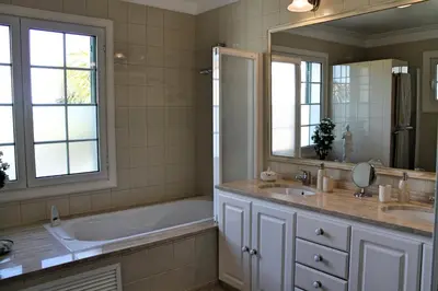 a bathroom with a tub and a sink and a mirror at Magnificent Funchal Villa Villa Luzia 5 Bedrooms Sea & City Views in Funchal