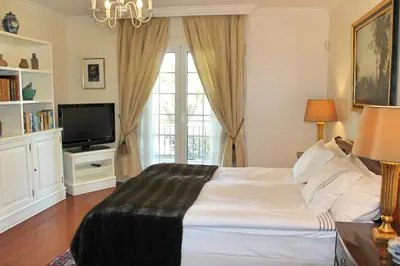 a bedroom with a large bed and a television at Magnificent Funchal Villa Villa Luzia 5 Bedrooms Sea & City Views in Funchal