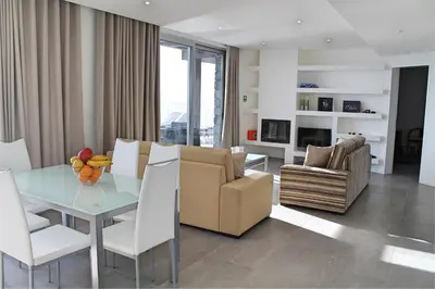 a living room with a glass table and white chairs at Spectacular Calheta Villa Villa Cliffscape 3 Bedrooms Panoramic Sea View in Estreito da Calheta