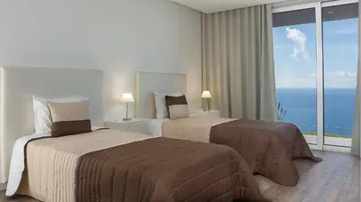 a hotel room with two beds and a large window at Spectacular Calheta Villa Villa Cliffscape 3 Bedrooms Panoramic Sea View in Estreito da Calheta