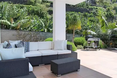 a patio with a white couch and a table at Extravagant Calheta Villa The Designhouse 4 Bedrooms Stunning Sea Views in Arco da Calheta