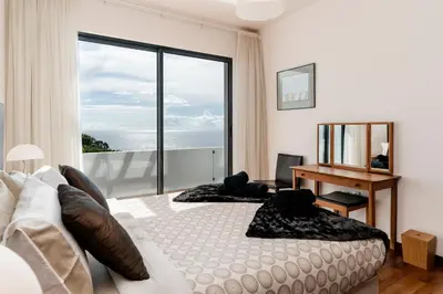 a bedroom with a bed and a desk and a window at Extravagant Calheta Villa The Designhouse 4 Bedrooms Stunning Sea Views in Arco da Calheta