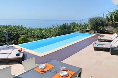 a swimming pool in a villa with a view of the ocean at Extravagant Calheta Villa The Designhouse 4 Bedrooms Stunning Sea Views in Arco da Calheta