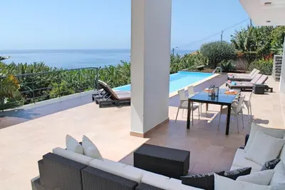 a patio with a table and chairs and a pool at Extravagant Calheta Villa The Designhouse 4 Bedrooms Stunning Sea Views in Arco da Calheta