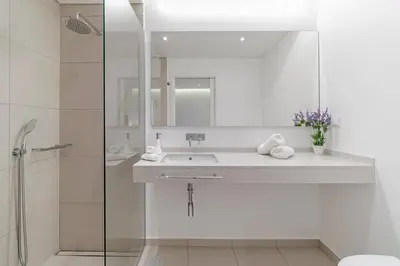a white bathroom with a sink and a shower at Luxury Calheta Villa Casa Calheta Heights 3 Bedrooms Stunning Sea Views in Calheta