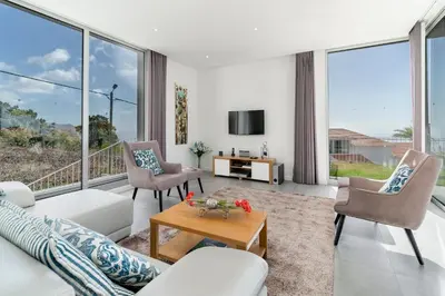 a living room with white furniture and large windows at Luxury Calheta Villa Casa Calheta Heights 3 Bedrooms Stunning Sea Views in Calheta