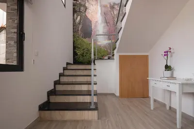 a staircase in a house with a painting on the wall at Luxury Calheta Villa Casa Da Rosalina 5 Bedrooms Stunning Sea Views in Calheta