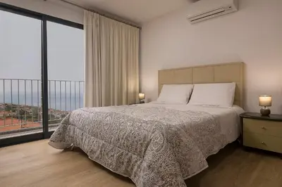 a bedroom with a bed and a large window at Luxury Calheta Villa Casa Da Rosalina 5 Bedrooms Stunning Sea Views in Calheta