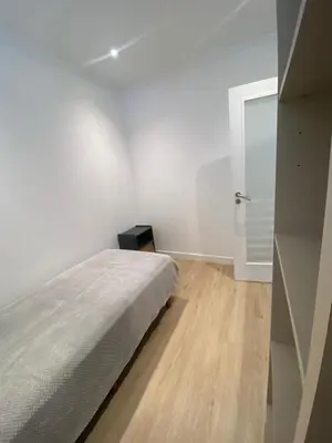 a white bedroom with a bed and a glass door at Funchal Center Apartment II in Funchal