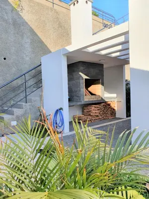 a house with a stone fireplace in a yard at Villa Brava Atlântico in Ribeira Brava