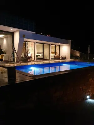 a swimming pool in front of a house at night at Villa Brava Atlântico in Ribeira Brava