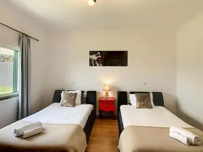 two beds in a room with a red night stand at Villa Prainha by LovelyStay in Caniçal