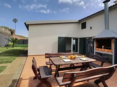 a patio with a table and chairs and a fireplace at Villa Prainha by LovelyStay in Caniçal
