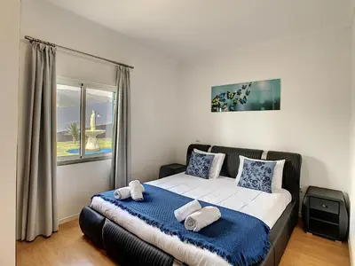 a bedroom with a large bed with a window at Villa Prainha by LovelyStay in Caniçal
