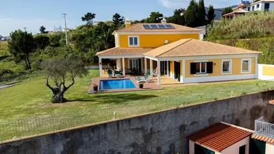 a yellow house with a swimming pool on a hill at Bellevue Villa Madeira Magnificent Sea View in Prazeres