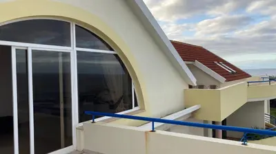 a balcony of a house with a large window at Costa Azul in Porto Moniz
