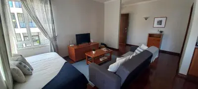 a living room with a bed and a couch and a tv at Costa Azul in Porto Moniz