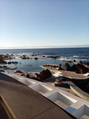 a swimming pool with the ocean in the background at Costa Azul in Porto Moniz