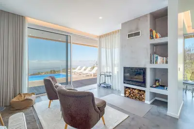 a living room with two chairs and a fireplace at Casa Luz by LovelyStay in Prazeres