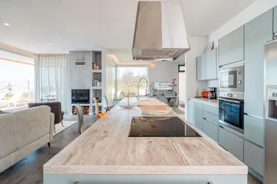 a kitchen and living room with a wooden table at Casa Luz by LovelyStay in Prazeres