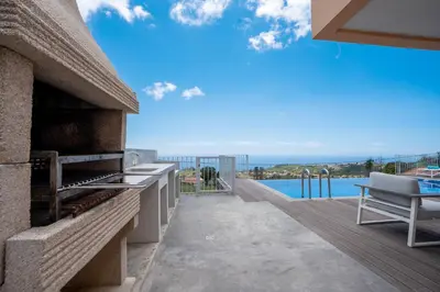an outdoor patio with a view of the ocean at Casa Luz by LovelyStay in Prazeres
