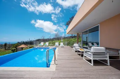 a pool with chairs and a table next to a house at Casa Luz by LovelyStay in Prazeres
