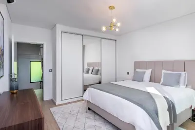 a white bedroom with a large bed and a tv at Villa Belmonte by LovelyStay in Ponta do Sol