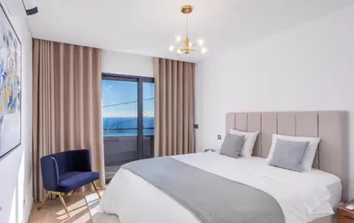 a bedroom with a large bed and a blue chair at Villa Belmonte by LovelyStay in Ponta do Sol