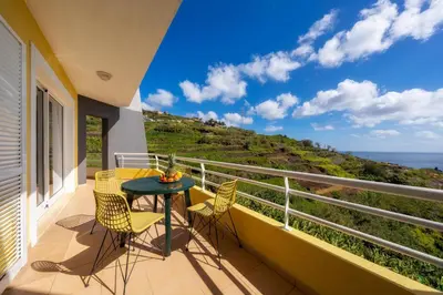 a balcony with a table and chairs and a view of the ocean at Sea View by Atlantic Holiday in Caniço