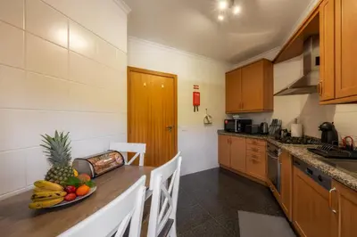 a kitchen with a table with a bowl of fruit on it at Sea View by Atlantic Holiday in Caniço