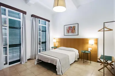 a bedroom with a bed and two chairs and a table at Murças74 - Studio Apartments in Funchal