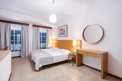 a hotel room with a bed and a table and a desk at Murças74 - Studio Apartments in Funchal