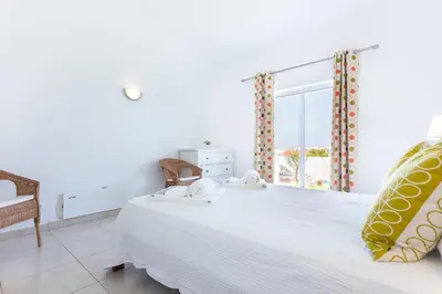 a bedroom with a large white bed and a window at CoolHouses Algarve Lagos, V3 Casa Evasion in Lagos