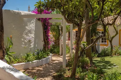 a patio with a table and chairs under an umbrella at Two bedroom apartment with garden view in Luz in Luz