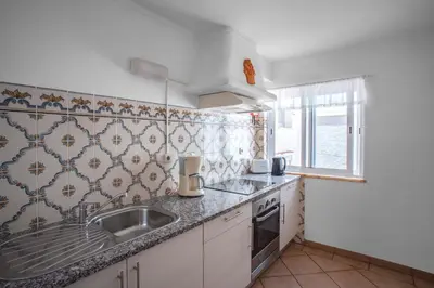 a small kitchen with a sink and a window at Two bedroom apartment with garden view in Luz in Luz