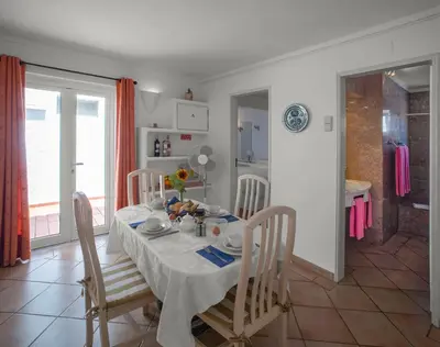 a dining room with a table and chairs and a kitchen at Two bedroom apartment with garden view in Luz in Luz