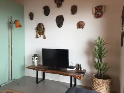 a living room with a tv on a wooden table at Mango House in Arco da Calheta