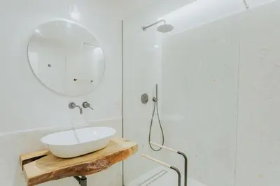 a white bathroom with a sink and a mirror at Mango House in Arco da Calheta